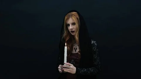 Gothic witch with candle on dark background Stock Footage 117540076