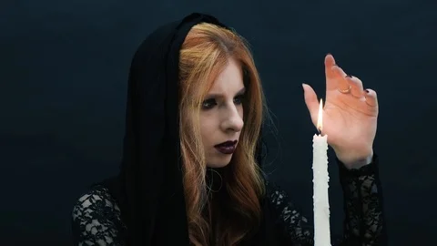 Gothic witch with candle on dark background Stock Footage 117541030