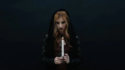 Gothic witch with candle on dark background Stock Footage 117541101