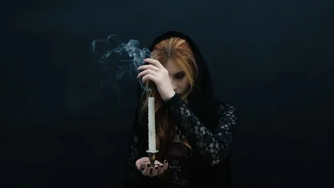 Gothic witch with candle on dark background Stock Footage 117545803