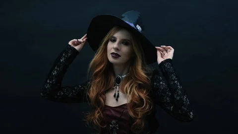 Gothic witch with hat on dark background Stock Footage 117549545