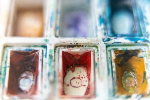 Gouache paint containers close up. Dirty artist pallet. Stock Photos