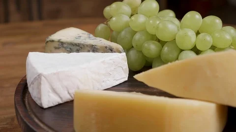 Gouda, brie and dorblu cheese served with white grapes Stock Footage 105368070