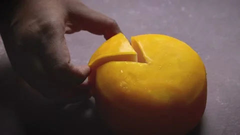 Gouda cheese wheel cut in slice being picked by hand. traditional dutch chees Stock-Footage 311878856