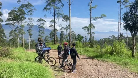 A goup of Cyclists with a blue sky &amp; tall trees background, West Java, Indonesia Stock Footage 344573614