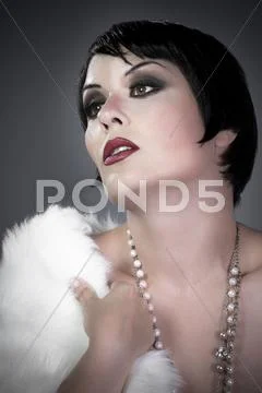 Gourgeos brunette flapper wearing pearls and fur Stock Photos