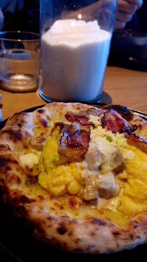 Gourmet Breakfast Pizza with Scrambled Eggs and Bacon on Restaurant Table Stock Footage 338993405