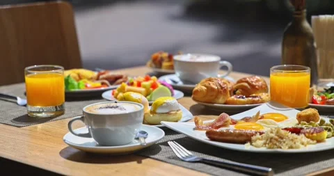Gourmet breakfast spread on outdoor table, coffee, juice, eggs Stock Footage 327736622
