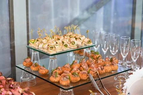 Gourmet buffet table with stuffed pastry profiteroles and cucumber canapes .. Stock Photos