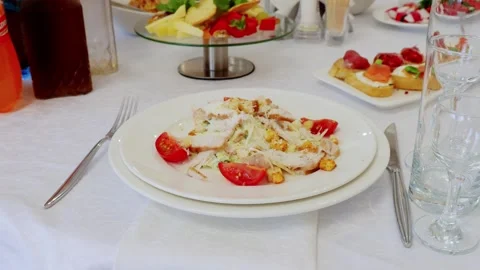 Gourmet caesar salad featuring grilled chicken, ripe cherry tomatoes on pristine Stock Footage 332570861