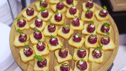 Gourmet canapes with beetroot cream and greens on wooden platter Stock Footage 314856901