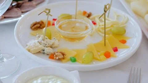 Gourmet cheese selection featuring multiple varieties, accompanied by honey Stock Photos