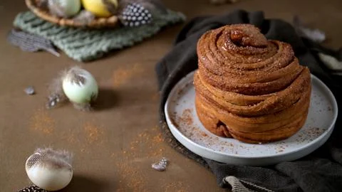 Gourmet Cinnamon Roll with Easter Table Setting and Spring Decor Stock Photos