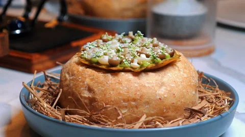 Gourmet dish featuring bread bowl filled with assorted vegetables and Stock-Footage 280020761