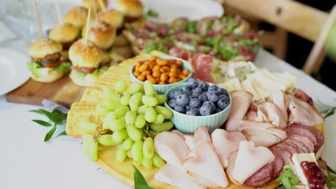 Gourmet grazing table spread with sliders and fresh fruit Stock Footage 273788594