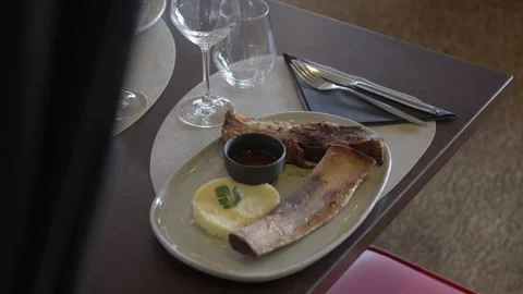 Gourmet meat dish with roasted bone marrow, mashed potatoes, and dip served on Stock Footage 336321496