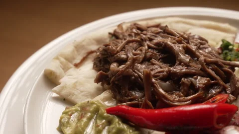 Gourmet plate of slow-cooked pulled meat served with fresh guacamole Stock Footage 335452191