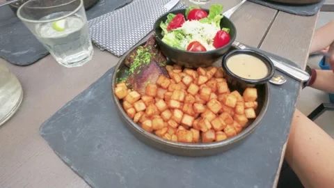 Gourmet Steak and Crispy Potato Cubes with Fresh Salad on Restaurant Table Stock Footage 345726257