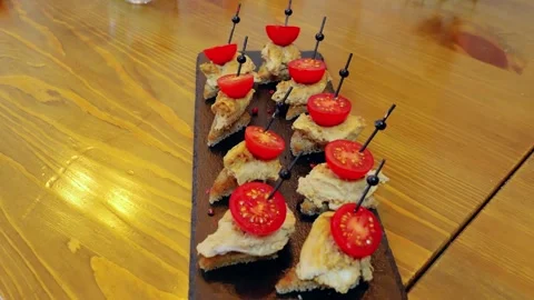 Gourmet triangular canapes spreading creamy pate, garnishing cherry tomatoes Stock Footage 331463795