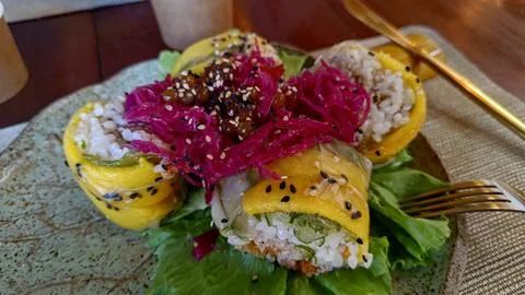 Gourmet vegan sushi rolls with mango, rice, and pickled cabbage. Foto stock