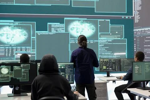Governmental hacker examines info on a big screen in agency office Stock Photos