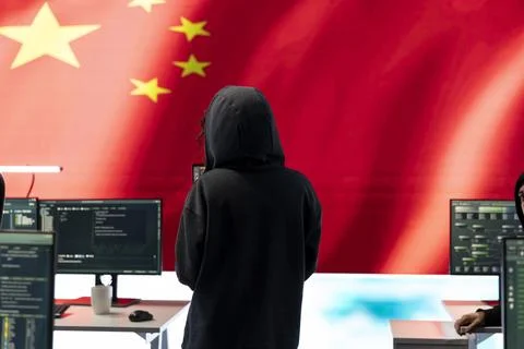 Governmental hacker in high tech office with Chinese flag shown on big screen Stock Photos