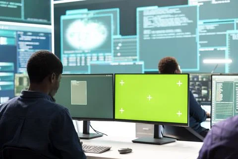 Governmental hackers working on computer with green screen to protect data Stockfoto's