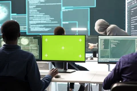 Governmental hackers working on computer with green screen to protect data Stockfoto's
