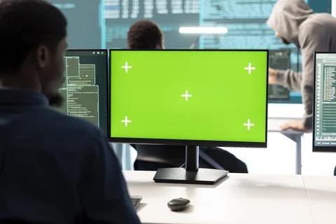 Governmental hackers working on computer with green screen to protect data Stockfoto's