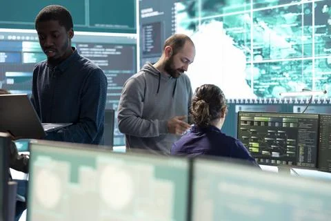 Governmental hackers working on computer network in high tech office Stock Photos