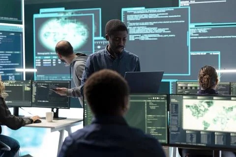 Governmental hackers working on computer network in high tech office Stock Photos