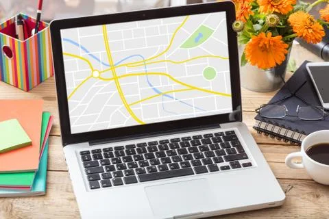 GPS, navigation. Map on a computer screen on a wooden office desk Stock Photos