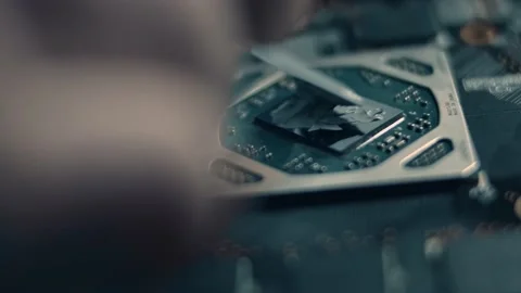 GPU Graphic card. Macro view of technician's hand spreading new thermal paste on Stock Footage 145776944