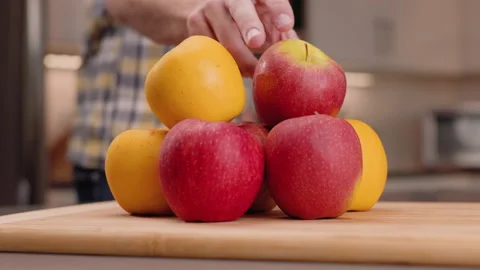 Grab an Apple from a Stack and Inspects to Eat Video stock 155110661