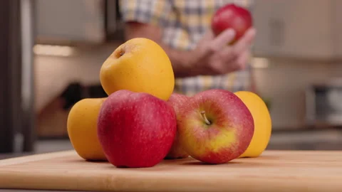 Grab an Apple from a Stack then Toss and Inspects to Eat Stock Footage 155110767