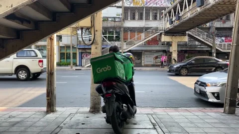 Grab delivery worker waiting for an order in Bangkok, Thailand 4K Stock Footage 171925597