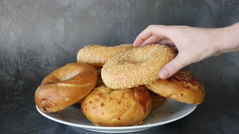Grabbing a Bagel form a Plate of Bagels Stock Footage