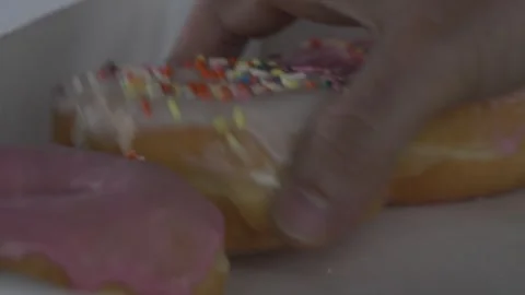 Grabbing A Donut CU Stock Footage 281023807