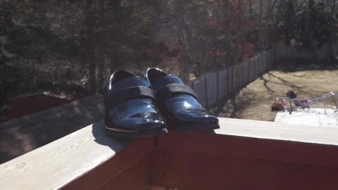 Grabbing tux shoes outside on deck Stock-Footage 103294366