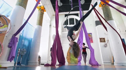 Grace women makes a gymnastic elements on the aerial hoop and silk in a studio Stock Footage 87991922