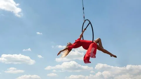 Graceful acrobat performs gymnastic trick on hoop Stock Photos