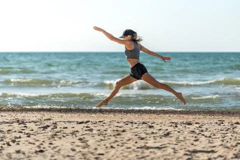 Graceful athlete performing split leap against horizon background Stock Photos