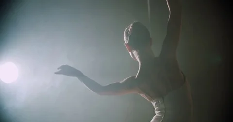 Graceful ballerina dancing elements of classical ballet in the dark with light Stock Footage 73423834