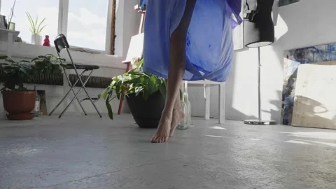 Graceful barefoot dancer in long blue dress dances in studio Stock Footage 138638121