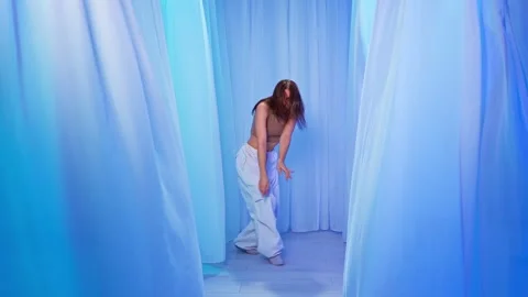 Graceful Contemporary Dance Surrounded by Soft Blue Curtains Stock Footage 306315736