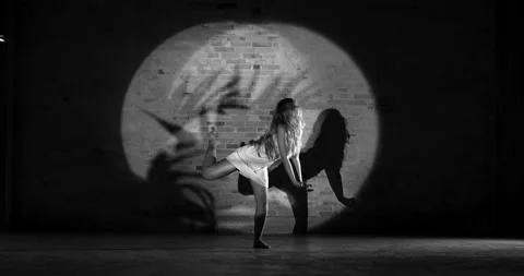A Graceful Dancer Dances Gently on a Dark Backdrop Stock Footage 158848285
