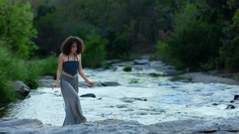 A graceful dancer expresses freedom and joy while performing alongside a serene Stock Footage 318919665