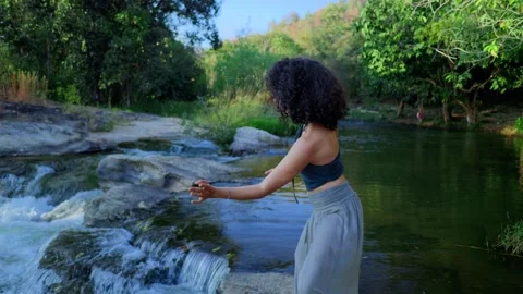 A Graceful Dancer Expressing Emotion Amidst Natures Beauty by the Stream, Moving Stock Footage 314280281