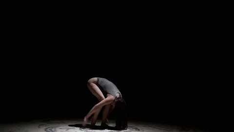 Graceful dancer jump with dust in the dark Stock Footage 129874588