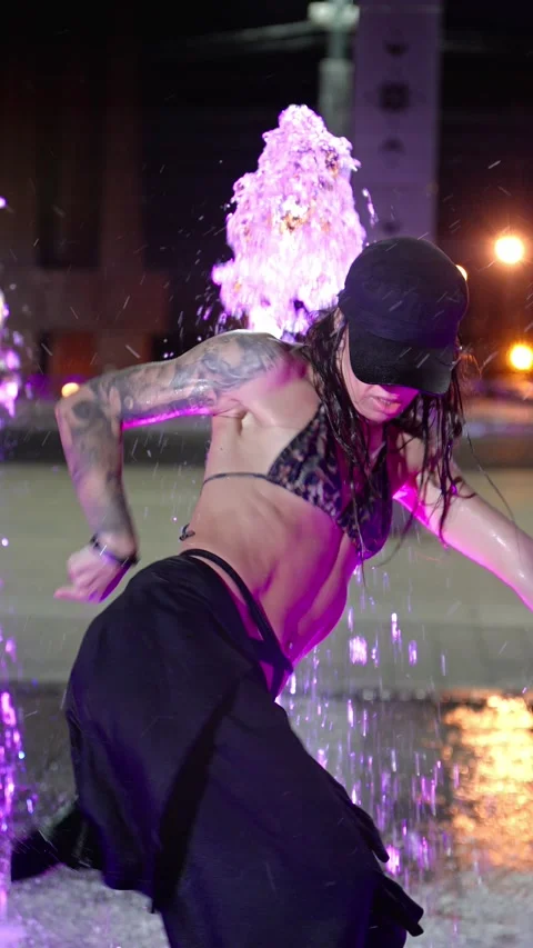 Graceful dancer performing modern choreography in colorful fountain. Video stock 292509105
